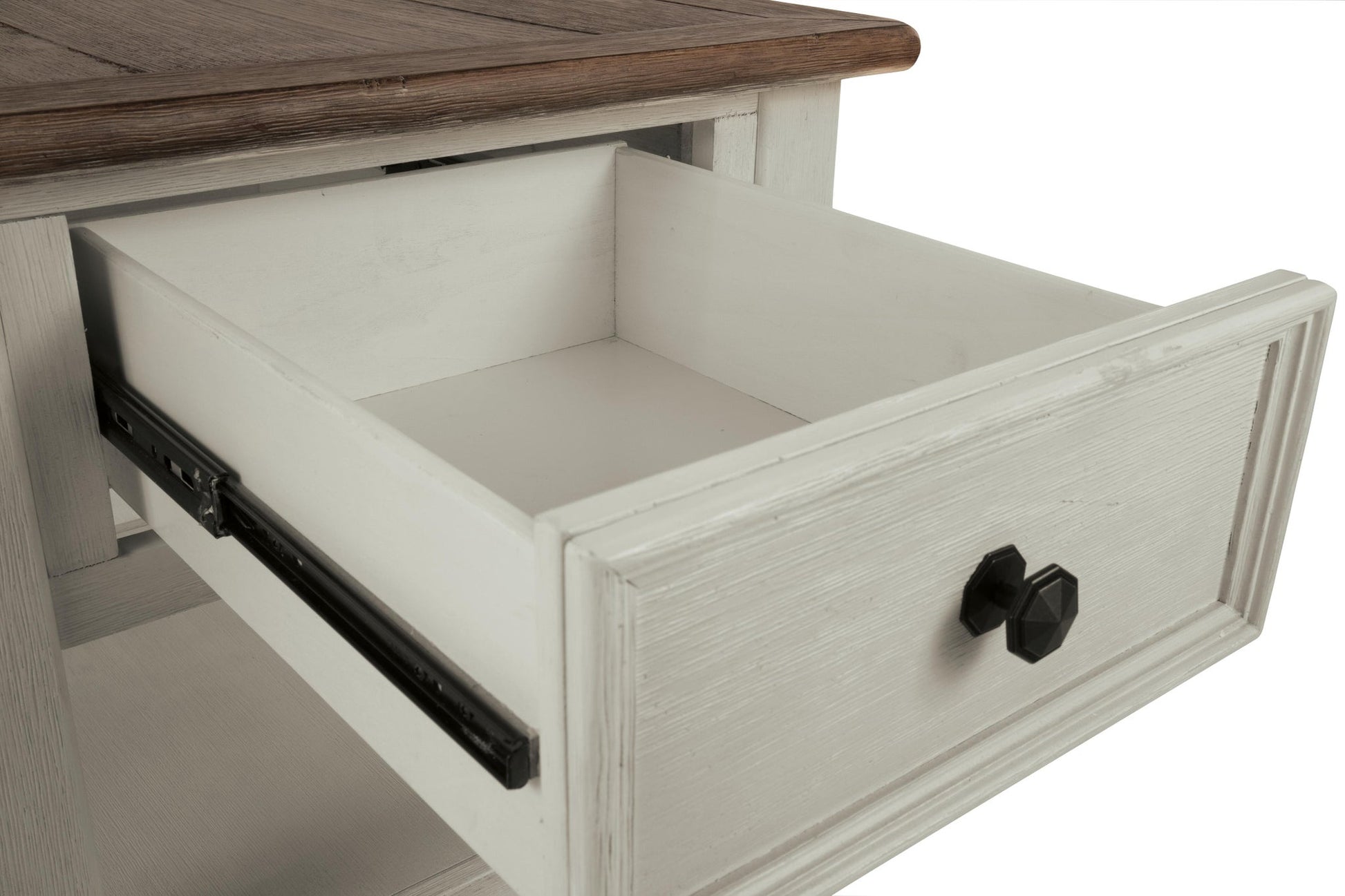 A close-up of the Bolanburg Rectangular End Table’s wooden drawer, partially open, reveals its two-tone distressed finish, black metal handles, and visible sliding hardware.