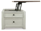 A side view of the Bolanburg Lift Top Cocktail Table in antique white, showcasing two storage drawers and a partially raised lift-top mechanism.
