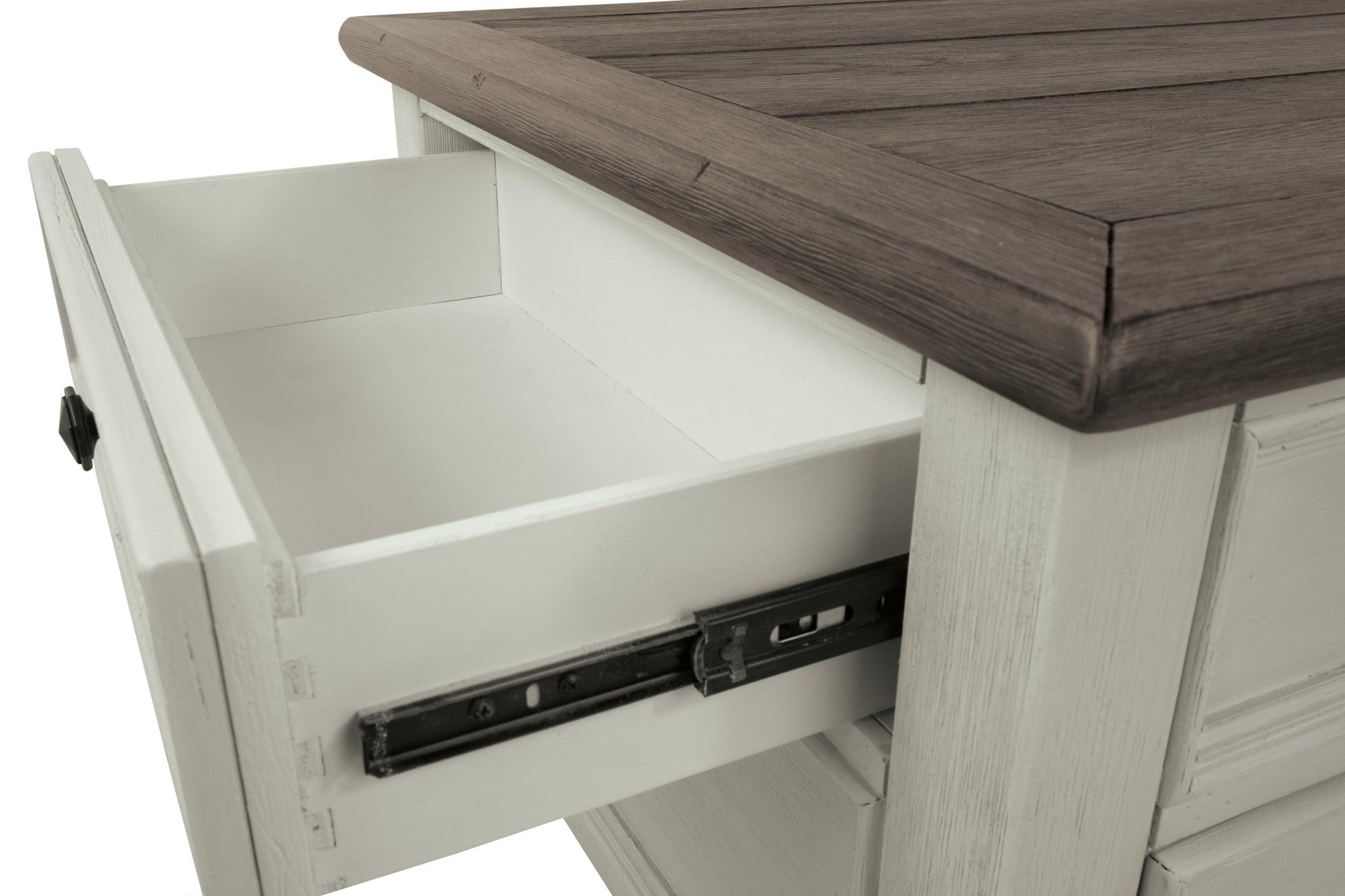 A close-up shows the Bolanburg Lift Top Cocktail Table’s wooden storage drawer, partially open to reveal metal sliding hardware. The table features an antique white finish with a contrasting dark wood top.