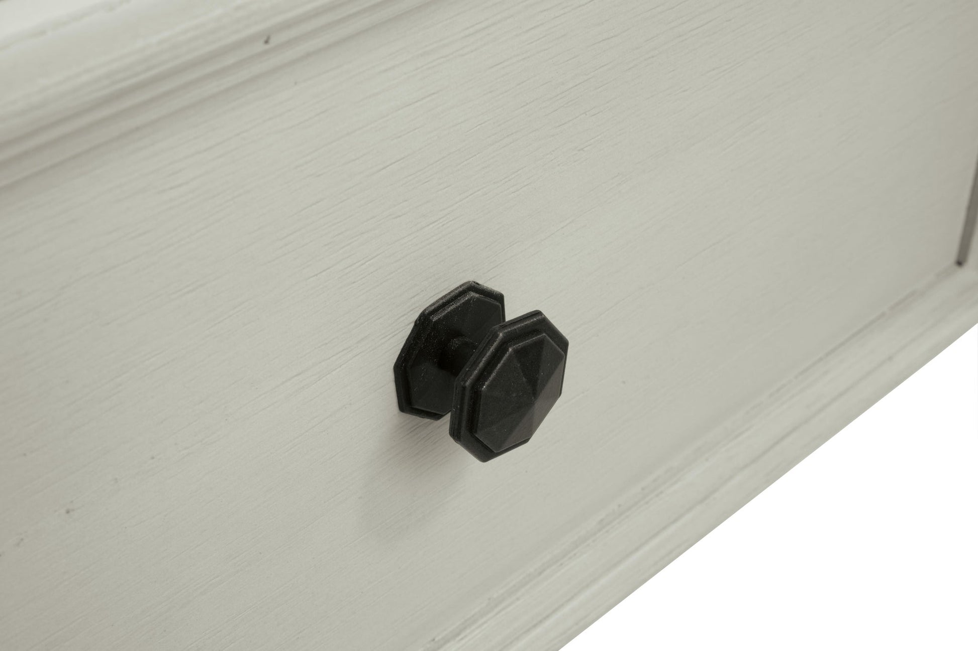Close-up of the Bolanburg Lift Top Cocktail Table, showcasing its light antique white finish and two black, geometric-shaped knobs on a storage drawer.