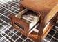 The Breegin Chair Side End Table, featuring an open drawer with books and set on a geometric-patterned rug, serves as a charming accent piece beside your chair.