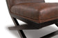 Close-up of the Sidewinder Accent Chair featuring a brown faux leather cushion and black wooden legs, set against a white background.