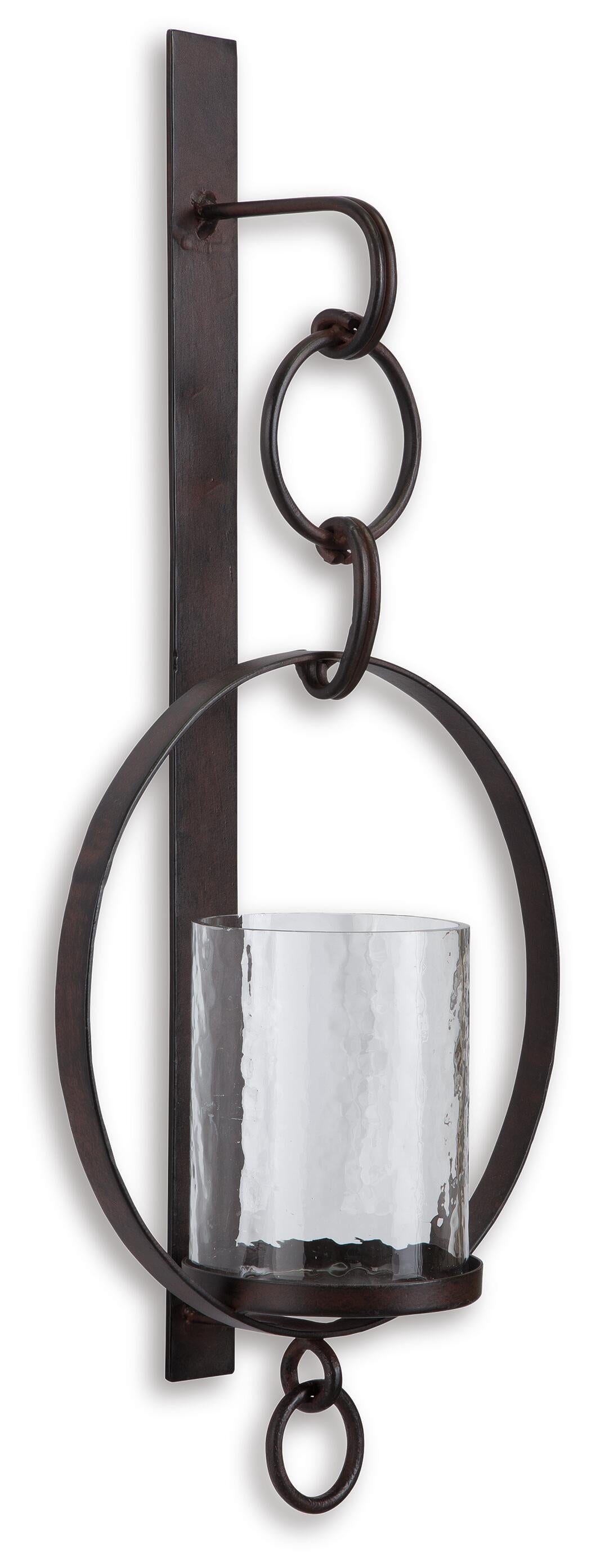 The Ogaleesha Wall Sconce features a bronze-tone metal frame with circular accents and a cylindrical glass enclosure, offering an elegant candle holder for your space.