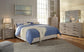 Modern bedroom with a queen bed featuring blue bedding, a beige headboard, two nightstands, and the Culverbach Dresser and Mirror in a weathered driftwood finish. Decorative art completes the look.