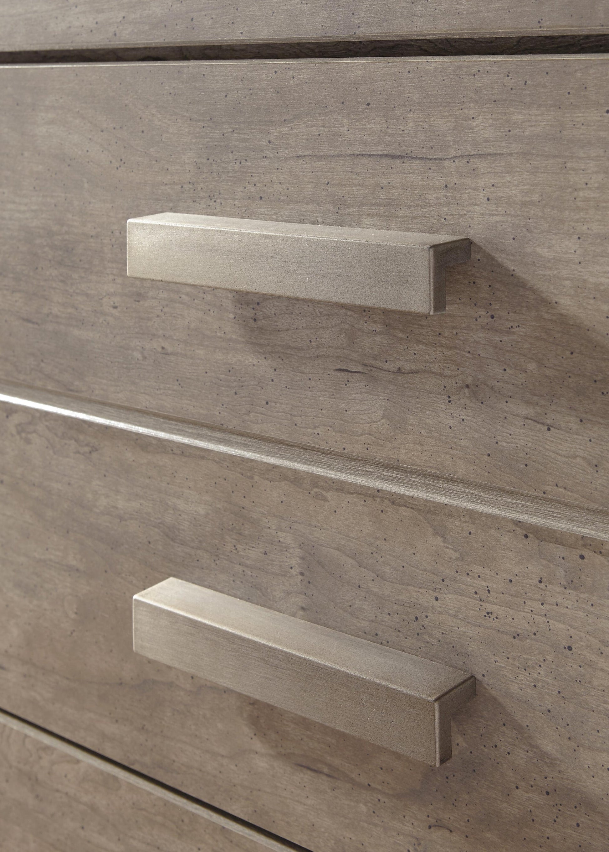Close-up of two wooden drawers with rectangular metal handles on the Culverbach Dresser and Mirror, featuring a light brown weathered driftwood finish.