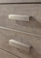 Close-up of two wooden drawers with rectangular metal handles on the Culverbach Dresser and Mirror, featuring a light brown weathered driftwood finish.