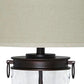 Close-up of the Tailynn Glass Table Lamp (1/CN), featuring a beige fabric drum shade, dark metal neck with side handles, and a clear wave-patterned glass base.