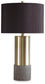 The Jacek Metal Table Lamp (2/CN) features a cylindrical brass base, textured gray faux concrete bottom, and a large black fabric drum shade for sleek modern elegance.