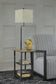 A square side table with a space-saving Shianne Metal Tray Lamp, a potted yellow flower, and two books stands next to a gray striped armchair on a textured dark rug.