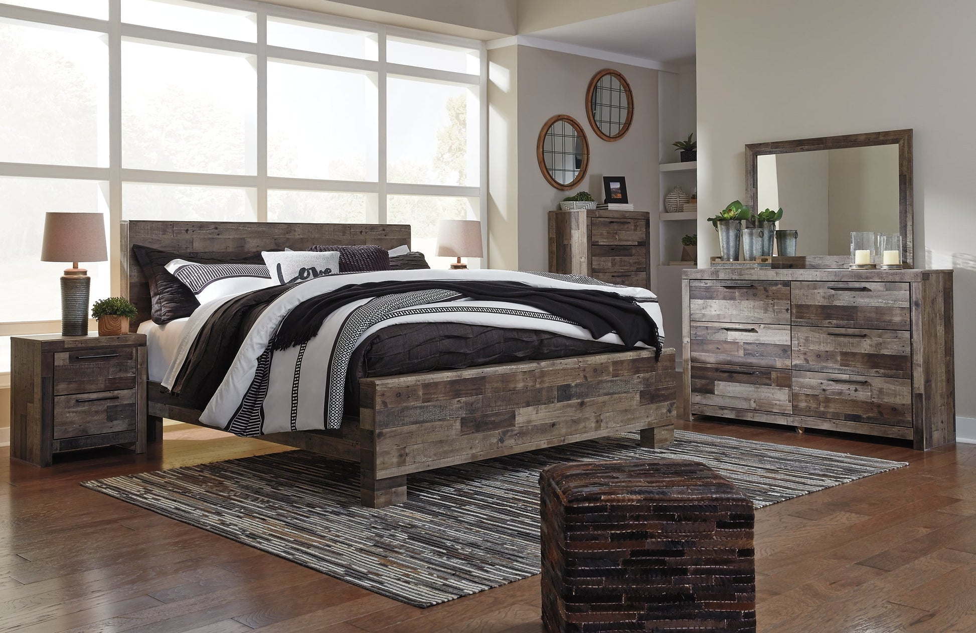 Derekson King Panel Bed with Mirrored Dresser, Chest and Nightstand at Walker Mattress and Furniture Locations in Cedar Park and Belton TX.