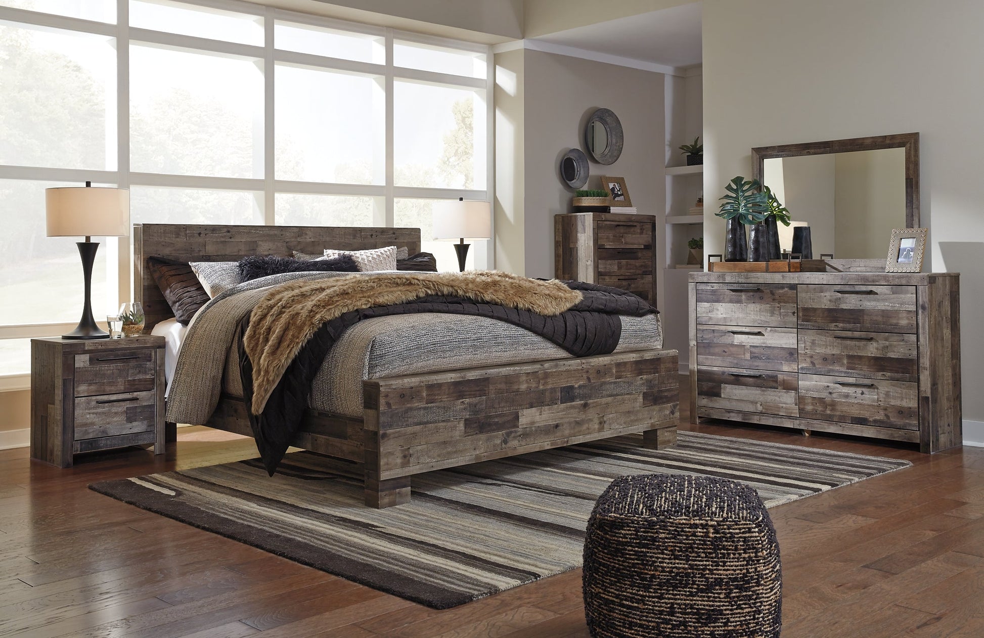 Derekson King Panel Bed with Mirrored Dresser, Chest and Nightstand at Walker Mattress and Furniture Locations in Cedar Park and Belton TX.