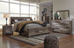 Derekson King Panel Bed with Mirrored Dresser, Chest and Nightstand at Walker Mattress and Furniture Locations in Cedar Park and Belton TX.